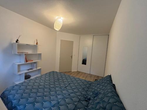 sypialnia z łóżkiem z niebieską kołdrą w obiekcie Proche Disneyland Paris - Appartement avec balcon sans vis a vis - parking prive Résidence calme w mieście Montévrain