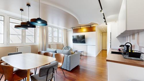 un salon avec une table et un canapé dans l'établissement Bluestay 87 - Magnifique Appartement à Paris, à Paris