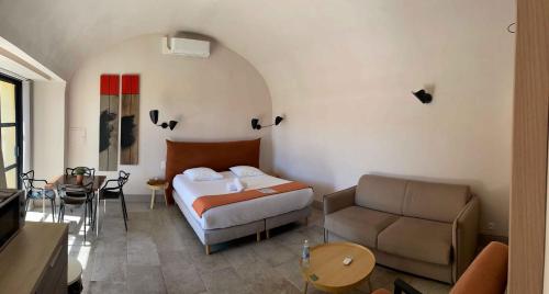 a bedroom with a bed and a couch and a table at Bastide de Ganay - Saint Jérôme in Aix-en-Provence
