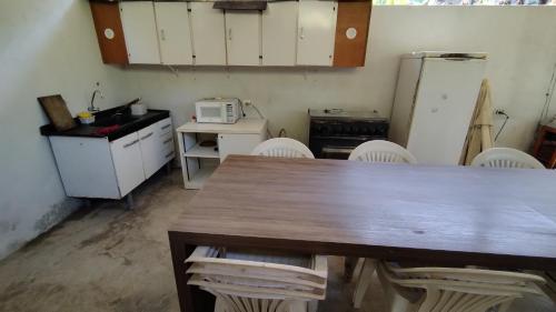 a kitchen with a table and chairs and a refrigerator at ESPAÇO ShEHERAZADE PISCINA & LAZER in Juquitiba
