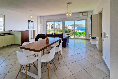 een keuken en woonkamer met een tafel en stoelen bij Słoneczny brzeg in Sarandë