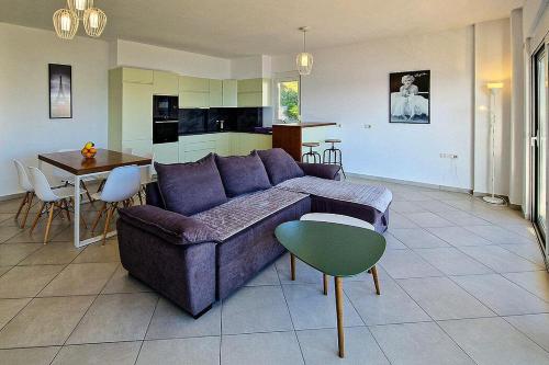 een woonkamer met een paarse bank en een tafel bij Słoneczny brzeg in Sarandë