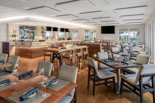 a restaurant with tables and chairs and a bar at Delray Sands Resort in Boca Raton