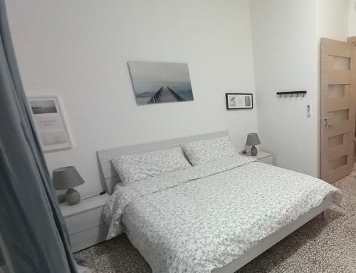 a white bedroom with a bed and a mirror at Casa Sabrina in Porto Torres