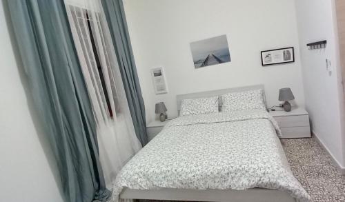 a white bedroom with a bed and a window at Casa Sabrina in Porto Torres