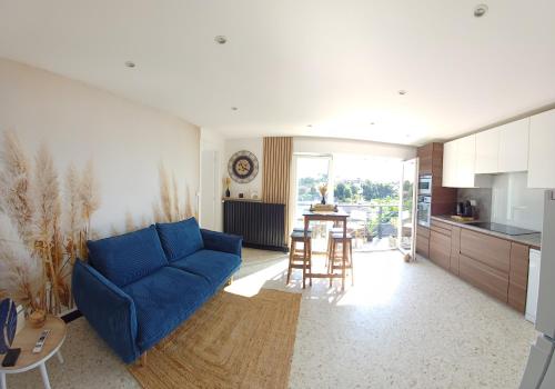 un salon avec un canapé bleu et une cuisine dans l'établissement Le Gîte de Mag, à Criel-sur-Mer