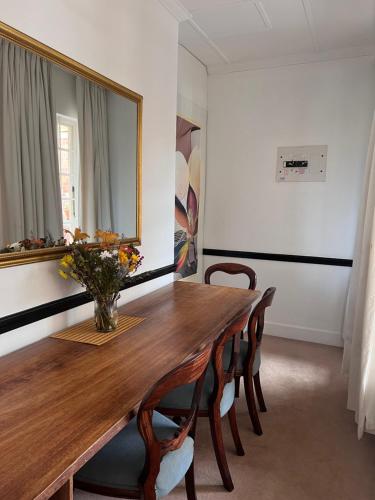 a dining room with a wooden table and a mirror at Edgehill in Pietermaritzburg