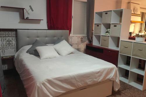 a bedroom with a large bed with white sheets at Golden Beach in Xeraco