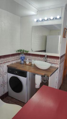 a bathroom with a sink and a washing machine at Golden Beach in Xeraco