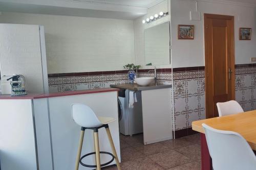 a kitchen with a counter and a sink and a table at Golden Beach in Xeraco