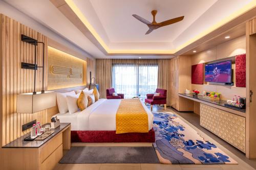 a hotel room with a bed and a tv at Ananta Spa & Resort Jaipur in Jaipur