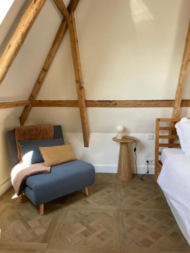 una camera con una sedia blu e un letto di B&B Suupmarkt a Dokkum
