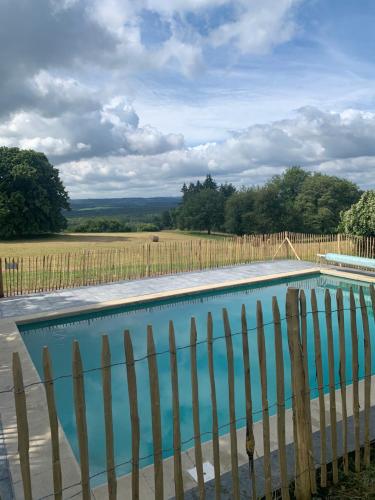 a swimming pool with a fence and a field at Gîte de Brohimont Vakantiehuis - Cottage - Exclusive Home of Silence - All in in Houyet
