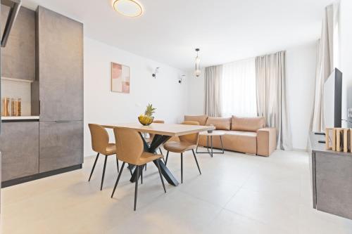 a kitchen and living room with a table and chairs at Lush Suites in Trogir