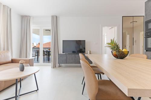 a kitchen and living room with a dining table and chairs at Lush Suites in Trogir