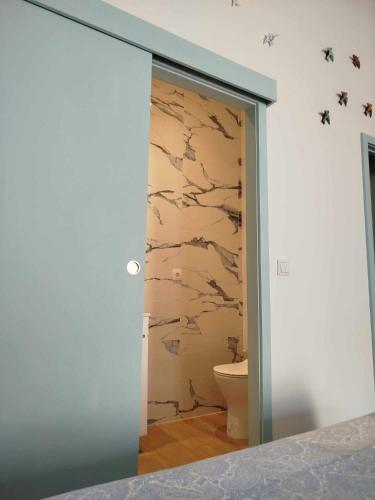 a bathroom with a door open to a toilet at Maria do Mar_As Três Marias in Matosinhos