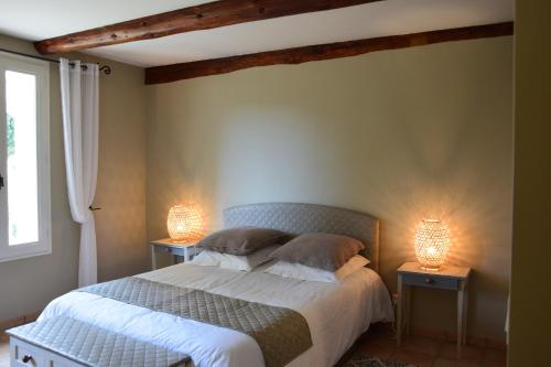 a bedroom with a bed with two lamps on it at La Chambre des Amis au Moulin des GYPSES, Ventoux in Mormoiron