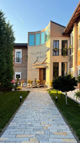 a building with a stone pathway in front of a building at Nurellari Winery Cellar and Guest House in Berat