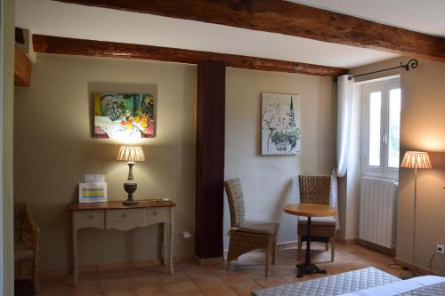 a bedroom with a desk and chairs and a window at La Chambre des Amis au Moulin des GYPSES, Ventoux in Mormoiron