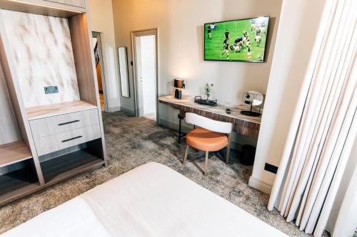 a bedroom with a desk and a tv on the wall at The Nines in Bangor