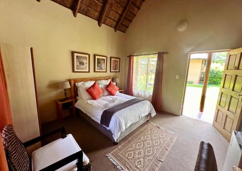 1 dormitorio con 1 cama y puerta a un patio en SETLHARE GUEST LODGE, en Ganyesa