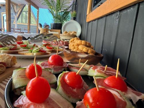 a buffet of food with sandwiches and tomatoes on skewers at Thethi Villas in Theth