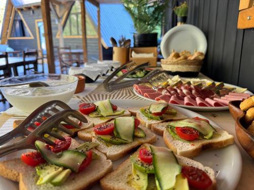 a table topped with sandwiches with fruits and vegetables at Thethi Villas in Theth