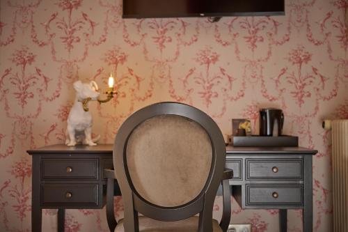a chair sitting in front of a desk with a candle at Hôtel du Château Bois Guibert in Bonneval