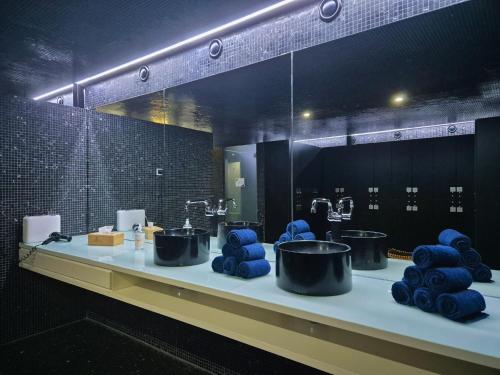 a bathroom with three sinks and blue towels at VIP Grand Lisboa Hotel & Spa in Lisbon