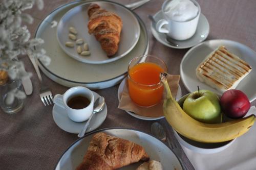 - une table avec des assiettes de nourriture pour le petit-déjeuner et du jus d'orange dans l'établissement Villa Maria Luigia, à San Biagio di Callalta