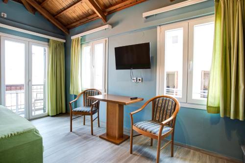 a room with a bed and two chairs and a table at Heliotrope The Studios in Mytilini