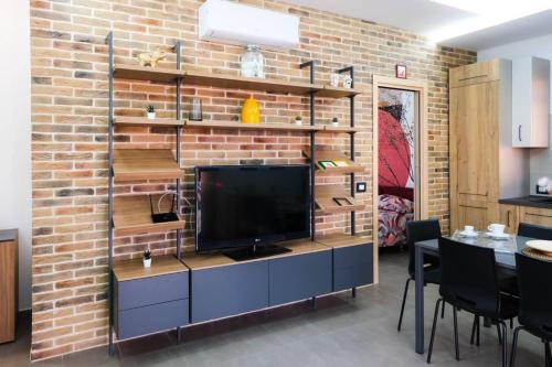 a living room with a tv on a brick wall at Domus del Gotha in Mazzarino