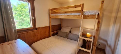 Cette petite chambre comprend 2 lits superposés et une table. dans l'établissement CHALET D- A216 - Appt 4-6 pers, à Les Deux Alpes