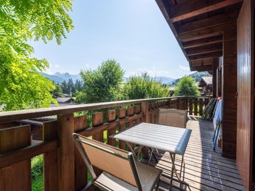 a wooden deck with a table and chairs on it at BOIS DE CHAMPELLE - 28 - Sublime CHALET 8 Pers in Morillon