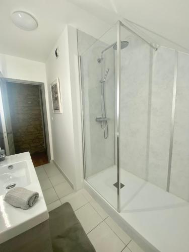 une salle de bain blanche avec une douche et un lavabo dans l'établissement Le Sainte Catherine - Appt centre-historique, à Dinan