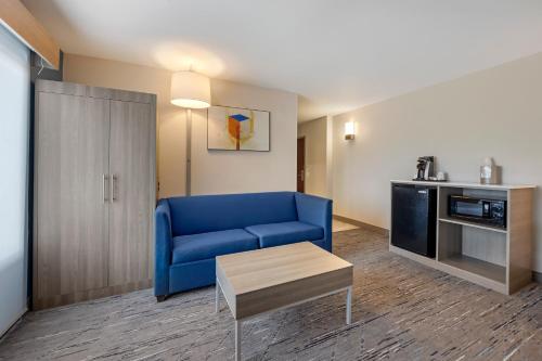 a living room with a blue couch and a kitchen at Holiday Inn Express White House by IHG in White House