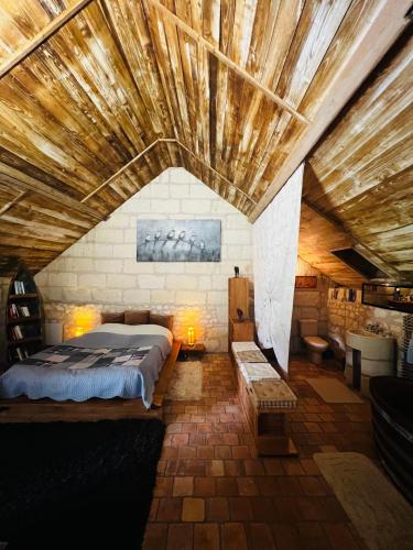 une chambre avec un lit et un plafond en bois dans l'établissement Château de la Thibaudière - Chambre des oiseaux, à Allonnes