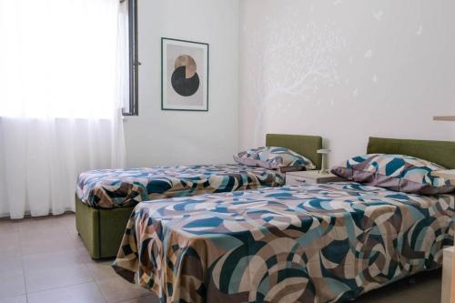 two beds sitting next to each other in a room at Domus del Gotha in Mazzarino