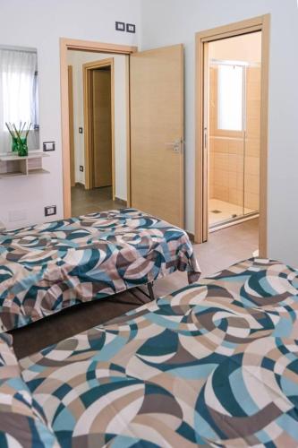 a large bedroom with two beds and a door at Domus del Gotha in Mazzarino