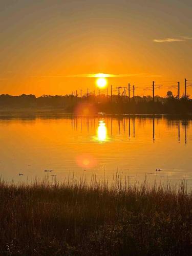 a sunset over a body of water with the sun setting at 37 Wamphassuc Rd Chteau Stonington in Stonington