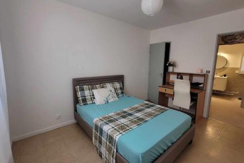 une chambre avec un lit et un bureau dans l'établissement Charmant appartement T3, à Avignon