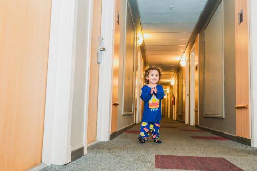 a young child is standing in a hallway at ibis Santiago Las Condes in Santiago