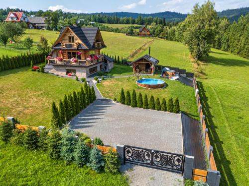 an aerial view of a house in a green field at Domek w górach DeLuxe sauna,jacuzzi,basen,hot tub-Nowy Targ blisko Białka ,Zakopane in Nowy Targ