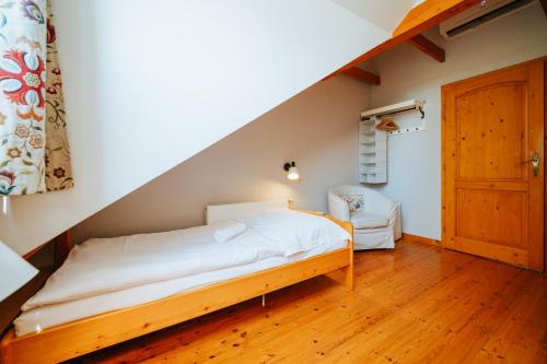 a small bedroom with a bed and a staircase at Penzion U maléřa in Hroznová Lhota