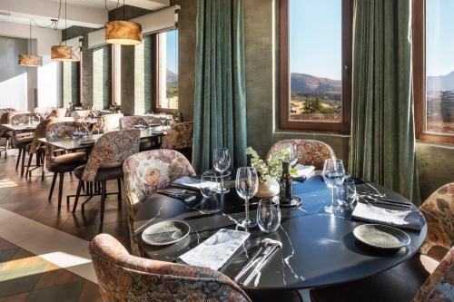 a dining room with tables and chairs and windows at Catalonia Ronda in Ronda