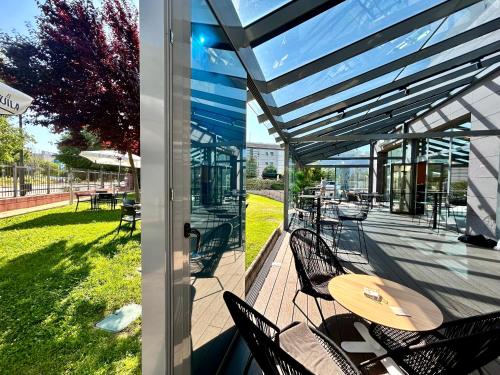 a patio with chairs and a table with a surfboard on it at Ramada by Wyndham Madrid Getafe in Getafe