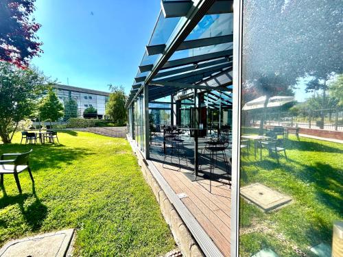 two pictures of a building with a deck in the grass at Ramada by Wyndham Madrid Getafe in Getafe