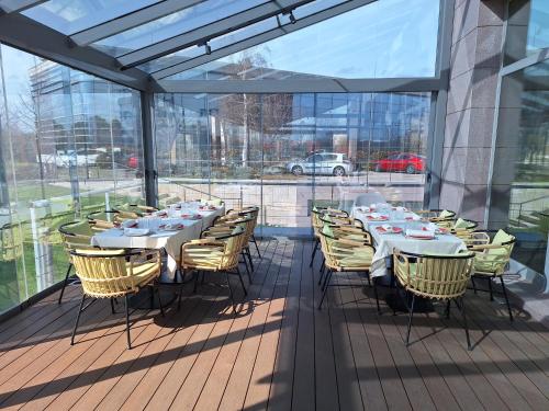 a dining room with tables and chairs on a balcony at Ramada by Wyndham Madrid Getafe in Getafe
