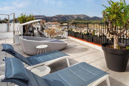 a patio with two chairs and a bench on a balcony at Catalonia Ronda in Ronda