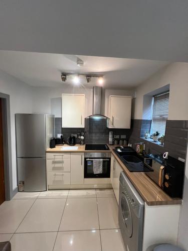 a kitchen with a stove and a refrigerator at Cairo Street Ground New in Warrington